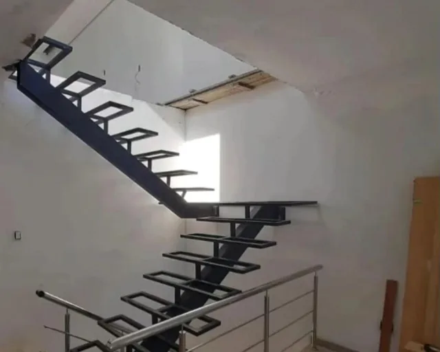 Escada metálica com degraus vazados e corrimão