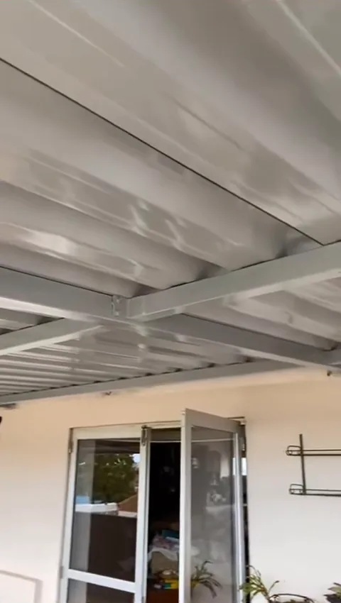 Forro branco de telha sanduíche numa área coberta com vista para a cidade